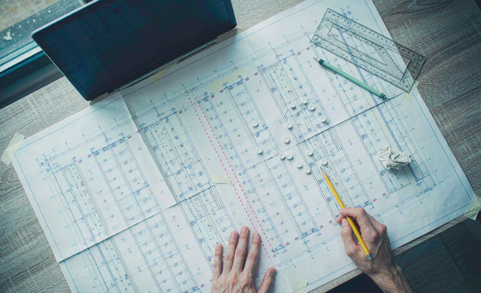 Project engineer marking a mobile compactor shelving room layout on a blueprint