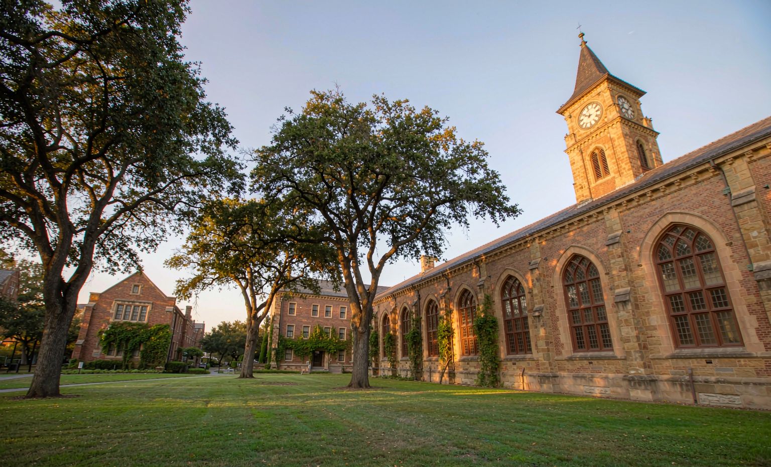 Historic university campus quad with academic building and clock tower at golden hour
