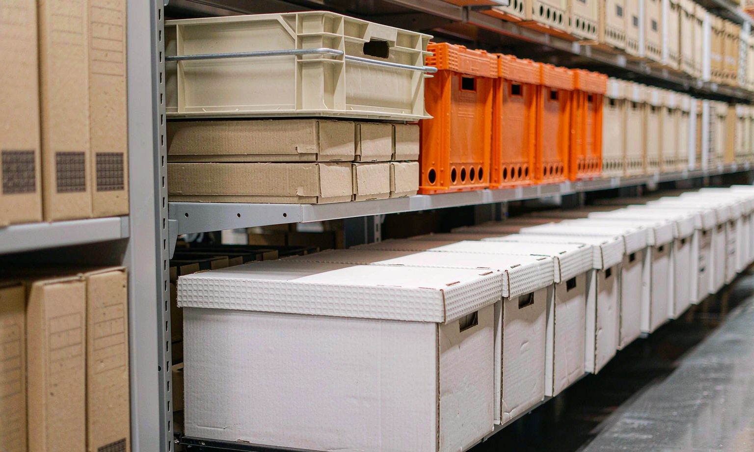 Archive boxes with clean label spines aligned on mobile compact shelving