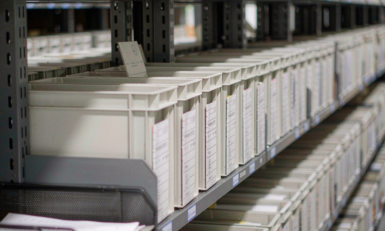 Rows of archive file boxes on mobile compact shelving shelves in a financial records room
