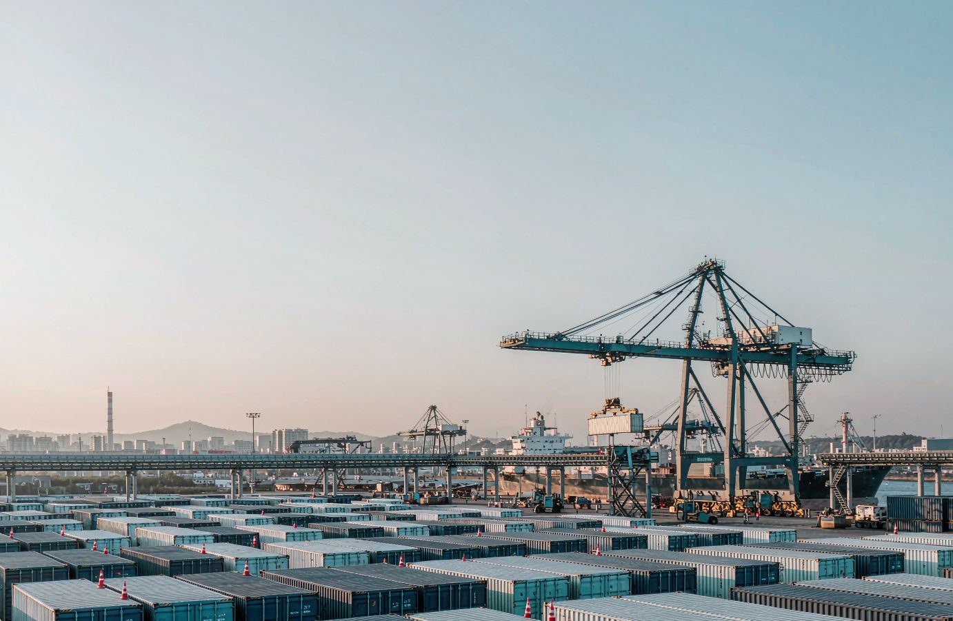 Container port with gantry cranes loading an export cargo ship